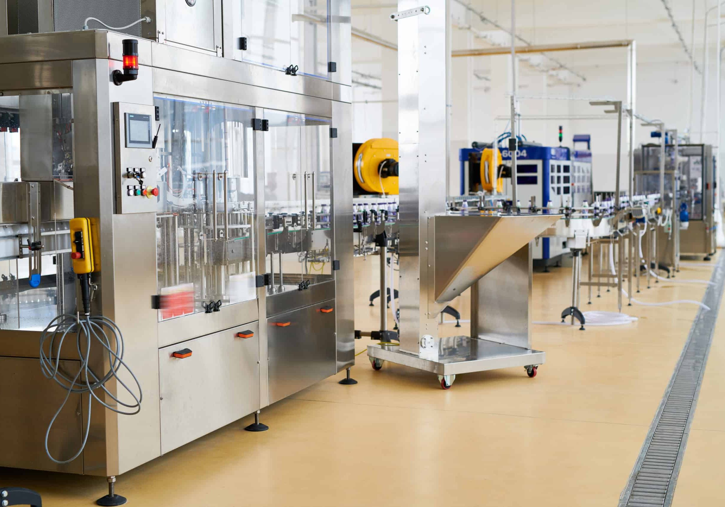 Interior of spacious dairy plant: conveyor belt and other modern equipment, no workers